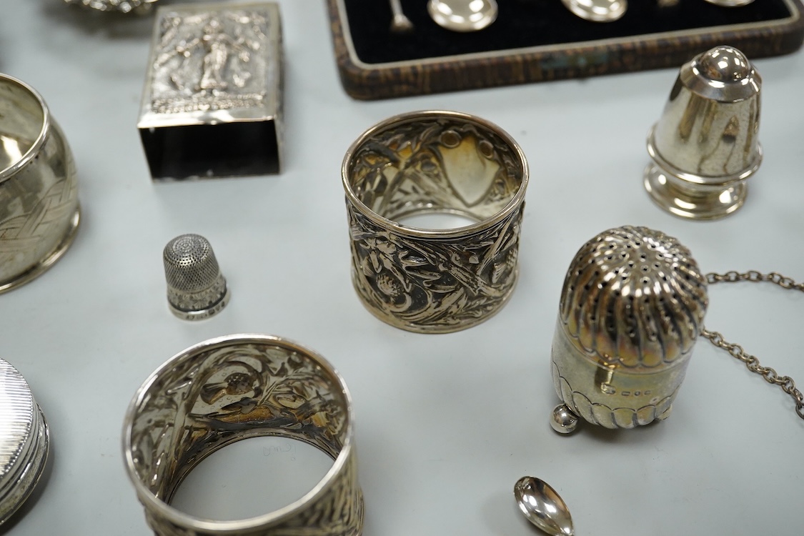 A collection silver and white metal to include a cased set of six George V seal top coffee spoons, Birmingham, 1927, a pair of Scottish napkin rings embossed with thistles, a pair of embossed heart shaped bonbon dishes,
